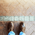 A person's feet in front of a line in the road.